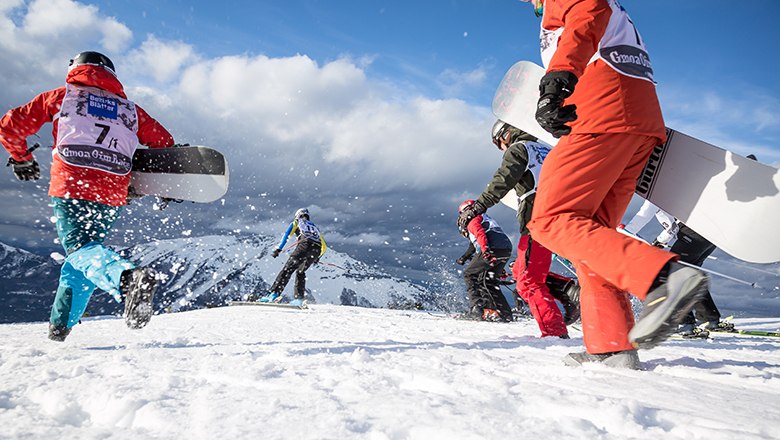 Action beim legendären Gmoa Oim Race auf der Gemeindealpe, © Michael Resch Snowboarder und Schifahrer rennen durch Schnee