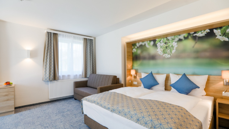 R&R Residenzen, Hotelzimmer, © Doris Schwarz-König Modernes Hotelzimmer mit Doppelbett, Sofa und großem Wandbild mit Blumenmotiv.