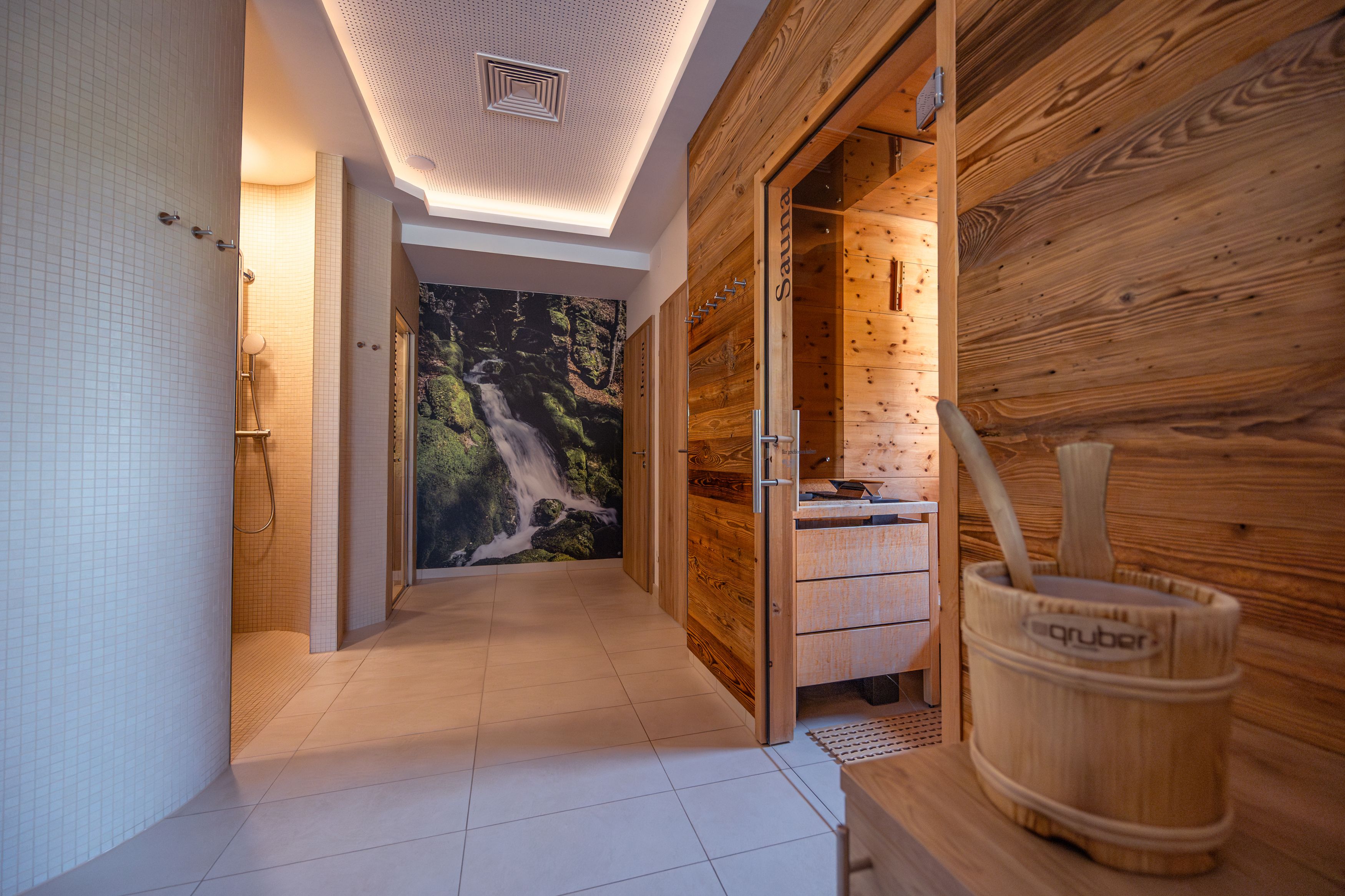 Innenansicht eines Wellnessbereichs mit Sauna und Dusche.