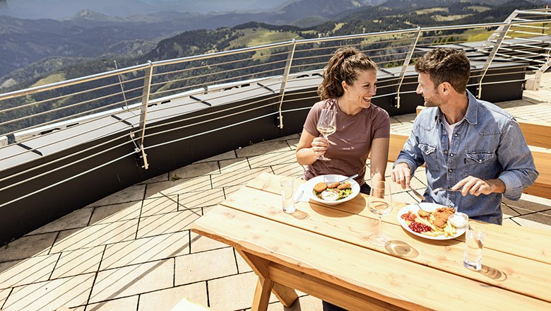 Mann und Frau sitzen auf Terrasse und essen