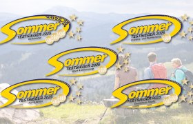 Drei Personen auf einer Holzbank mit Blick auf bewaldete Berge, darüber fünf gelbe Sommer-Logos mit Text 'Testsieger 2025' und goldenen Sternen.
