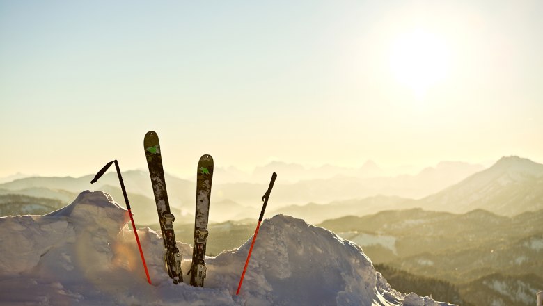 Skier in einem Schneehaufen mit Sonne im Hintergrund