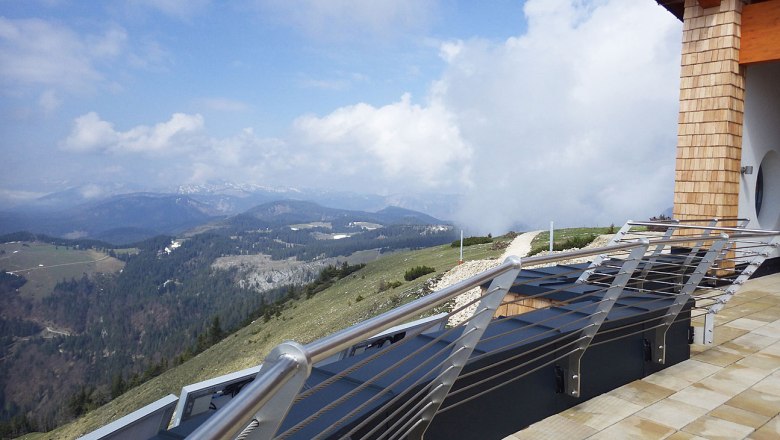 Aussicht vom Terzerhaus auf eine bergige Landschaft mit Wolken und einem Gel&auml;nder im Vordergrund.